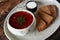 Traditional Ukrainian Russian borscht with white beans on the bowl. Plate of red beet root soup borsch on black rustick