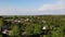 Traditional Ukrainian village. Huts among green trees, blue cloudy sky.  Aerial drone 4K, crane shot