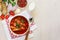 Traditional Ukranian soup borsch on a white napkin embroidered in red, copy space, top view.