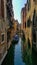 Traditional Venetian rowboat tied to the edge of a canal in Venice, Italy between the buildings