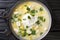 Traditional Venezuelan breakfast of chicken broth, with potatoes, eggs, cheese and cilantro close-up in a bowl. horizontal top