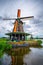 Traditional village with dutch windmills and river at sunset, Holland, Netherlands.