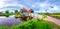 Traditional village with dutch windmills and river at sunset, Holland, Netherlands.