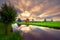 Traditional village with dutch windmills and river at sunset, Holland, Netherlands.