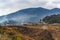 Traditional village and farm fields on the hillside in Bhutan in Himalaya mountains in the morning in February. White prayer flags