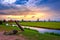 Traditional village at sunset, with dutch windmills, bridge and river on Zaanse Schans, Holland.