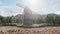 Traditional village windmill standing near the pond against the background of mountains and clouds. 3D Rendering