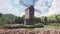 Traditional village windmill standing near the pond against the background of mountains and clouds. 3D Rendering