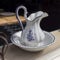 A traditional vintage white with a blue Dutch jug with blue painted flowers in the restaurant window.