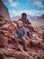 Traditional Wadi Rum bedouin and young tourist boy sitting on rocks portrait