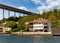 Traditional waterfront house, under Bosphorus bridge, and green hill with dense trees, Istanbul, Turkey