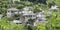 Traditional white houses with stone gray roofs on a hill. Spring landscape with lush foliage. City of Gjirokastra, Albania