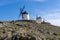 Traditional whitewashed Spanish windmills in La Mancha on a hilltop above Consuegra