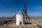 Traditional whitewashed Spanish windmills in La Mancha on a hilltop above Consuegra