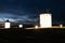 Traditional whitewshed Spanish windmills in La Mancha under a dark blue night sky