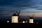 Traditional whitewshed Spanish windmills in La Mancha under a dark blue night sky