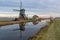 Traditional windmill and farm on dyke, blue colour, Netherlands