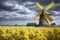 traditional windmill stands amidst a vibrant yellow flower field under a cloudy sky, exuding a serene, picturesque landscape, ai