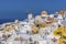 Traditional windmills and white buildings dominate the northern edge of the village of Oia, Santorini