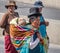 Traditional Woman Cholita in Typical Clothes with baby on her back during 1st of May Labor Day Parade - La Paz, Bolivia
