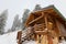 Traditional wood alpine chalet on a mountain slope against forest