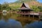 Traditional wood Thai house above lake