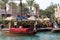 Traditional wooden arabic boat floats against the background of walking tourists in Madinat Jumeirah