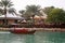 Traditional wooden arabic boat with tourists sails on turquoise water in Madinat Jumeirah