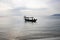 Traditional wooden boat in Cambodia. Sunrise sea landscape photo. Sea and sky view with boat silhouette.