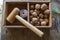 Traditional wooden hammer beats walnuts on the wooden table