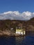 A Traditional wooden Norwegian House set close to the Waters edge next to a Navigational Marker and Light