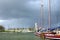 Traditional yacht near pier and clouds