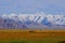 A traditional yurt with snow peak range behide.