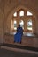 Traditionally Dressed Indian Lady Sitting in Arched Window Recess at Queen\\\'s Bath, Hampi, near Hospete, Karnataka, India