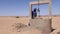 A traditionally dressed Moroccan Bedouin man looks for water at a dry well in the Sahara desert of Morocco.