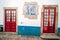 Traditonal red doors with white walls and blue accents in Obidos Portugal
