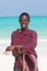 Traditonaly dressed maasai black man on picture perfect tropical Paje beach, Zanzibar, Tanzania, East Africa.