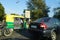 Traffic of Cars, Autos and Bikes on Indian Road in day time. People are present standing under trees away from sun light. : Punjab