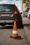 Traffic cone behind a broken down vehicle Orange traffic sign and a damaged  car