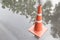 A traffic cone on the road in rain time and reflection