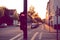 A traffic light for a cycling lane shows a red bicycle symbol at an intersection at early sunrise.