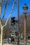 Traffic light, lantern, tree against the blue sky in spring in Paris, where people walk in good weather