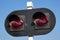 A traffic light for a railway crossing, two red lights against a blue sky. forbidding sign for leaving the tracks. traffic safety