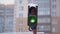 Traffic lights. Green flashing traffic signal. Winter, snow, snowfall.