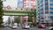 Traffic passes under a rail bridge on a busy downtown Tokyo main street. a subway train passes over the busy road as high rise bui