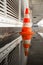 Traffic pylon reflected in a pool of water