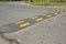 Traffic safety speed bump on an asphalt road. Speed bumps or speed breakers are traffic calming devices