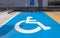 Traffic sign about handicapped symbol painted in bright blue . Disabled parking spaces