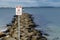 Traffic sign for High risk activity , avoid rocky coastal ocean wall.