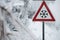 Traffic sign for icy road with sleet covered trees